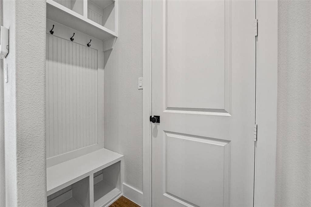 12413 Hornfels Drive, Krum, TX 76249 Built-in mudroom bench with cubby storage, beadboard backing, and upper shelving
