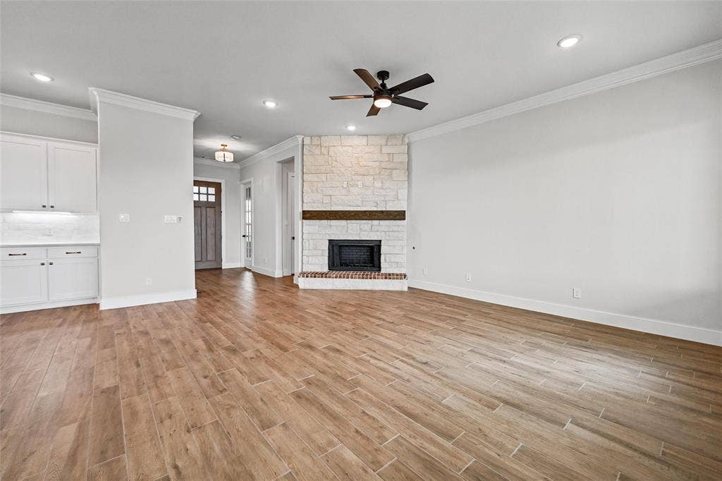 12413 Hornfels Drive, Krum, TX 76249 Wood-finish flooring throughout, featuring a stone-clad fireplace with a wood mantle