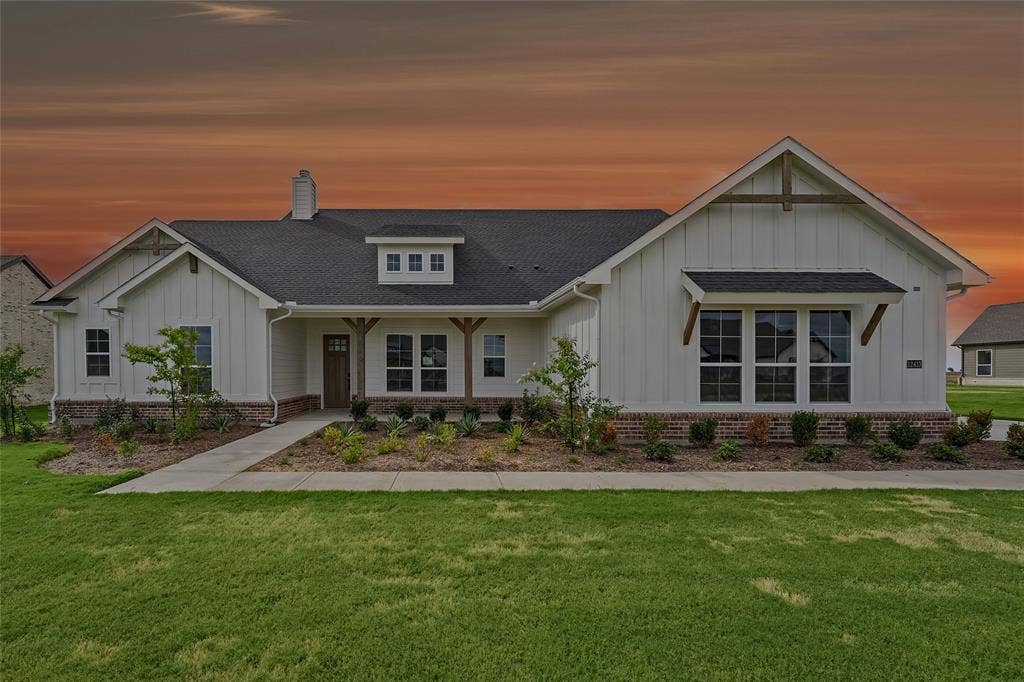 12413 Hornfels Drive, Krum, TX 76249 Craftsman-style exterior featuring white vertical siding, dark shingle roof, brick skirting, and an attached front porch with wood columns