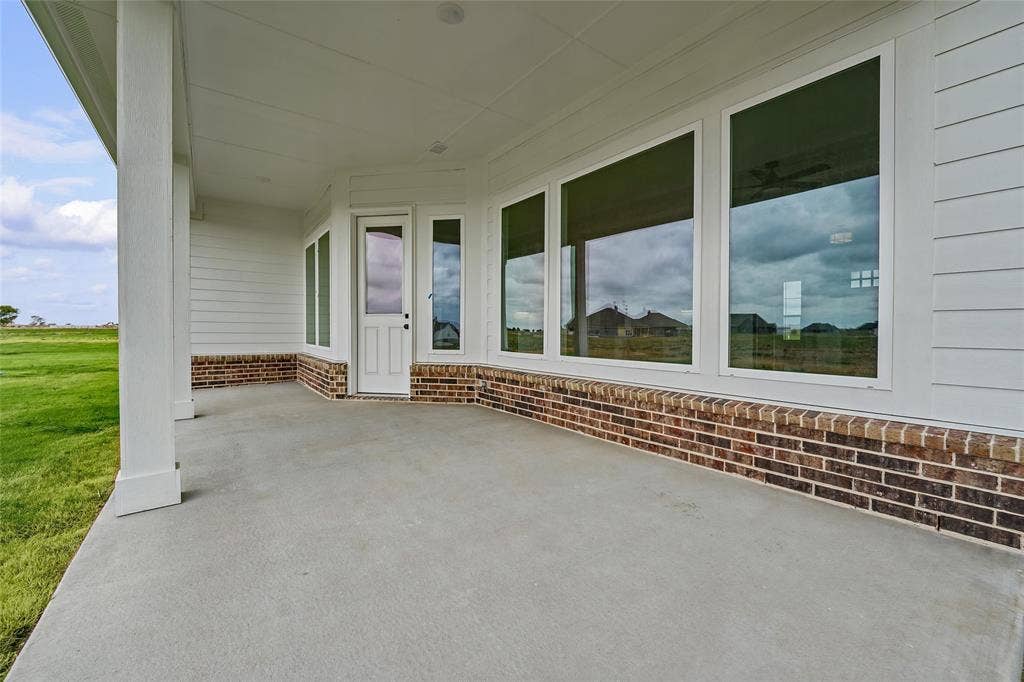 12413 Hornfels Drive, Krum, TX 76249 Covered concrete patio with white columns and a white paneled ceiling
