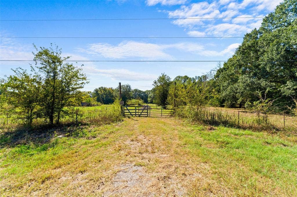 11691 Betty Lane, Kaufman, TX 75142 Gated entry to a expansive natural landscape with a gravel pathway