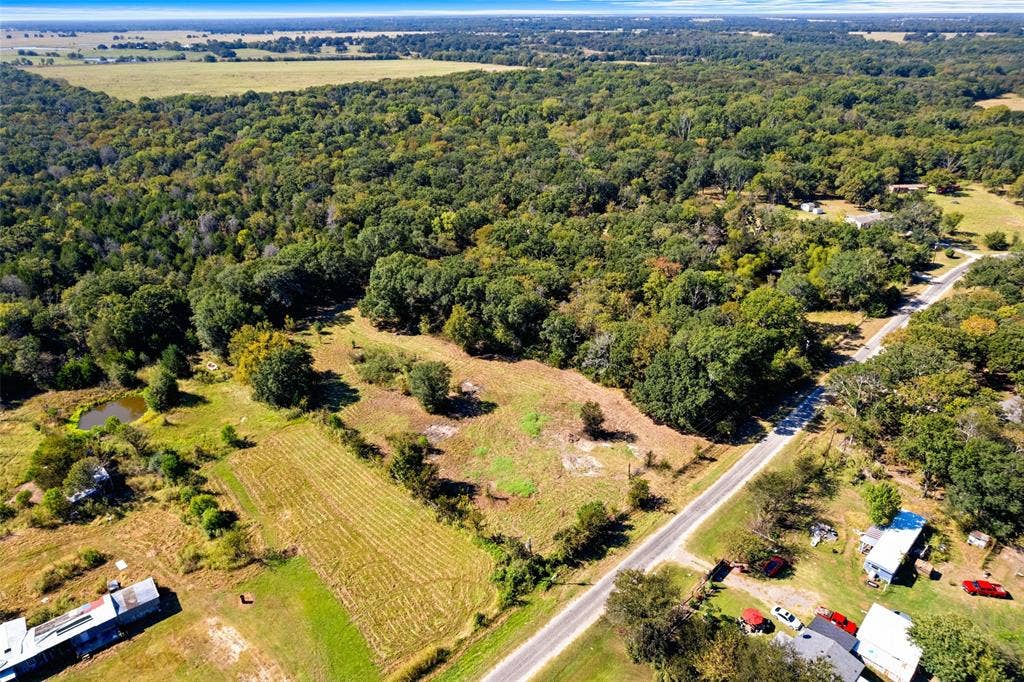 11691 Betty Lane, Kaufman, TX 75142 Expansive rural acreage featuring a natural pond, a cultivated field, and dense mature tree coverage