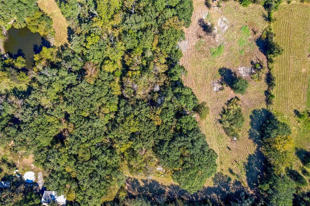 11691 Betty Lane, Kaufman, TX 75142 Expansive land parcel featuring a mix of mature tree coverage and cleared areas, with a visible pond and varied terrain