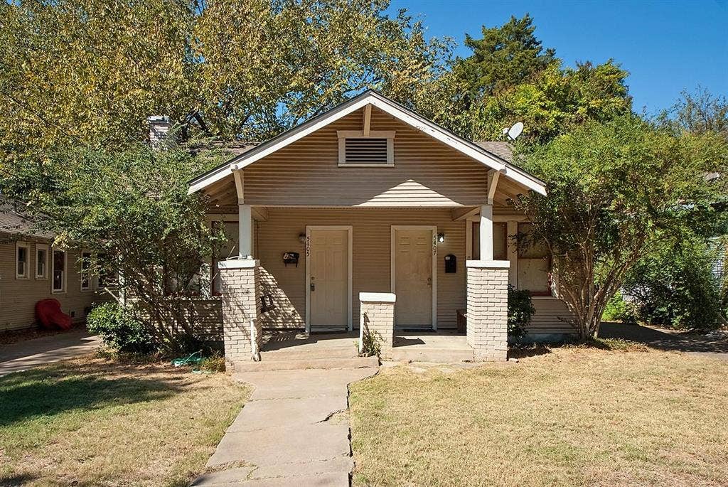 5405 Worth Street, Dallas, TX 75214 A cozy house with a charming front porch and a well-kept yard, creating a warm and inviting atmosphere.