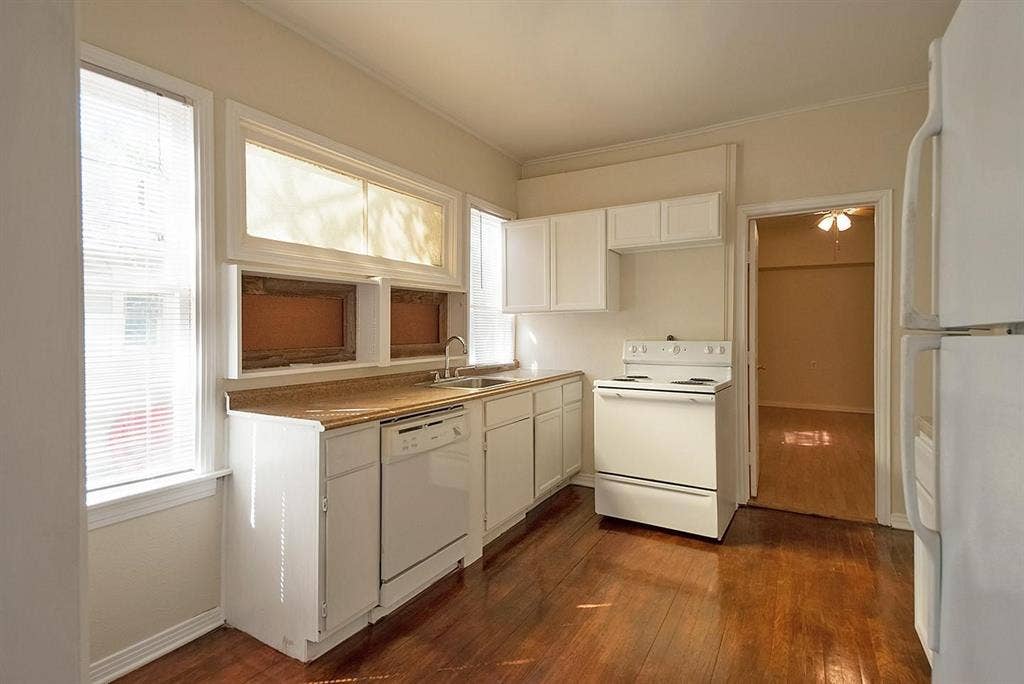 5405 Worth Street, Dallas, TX 75214 A cozy kitchen with white cabinets, a dishwasher and a stove, creating a clean and inviting cooking space.