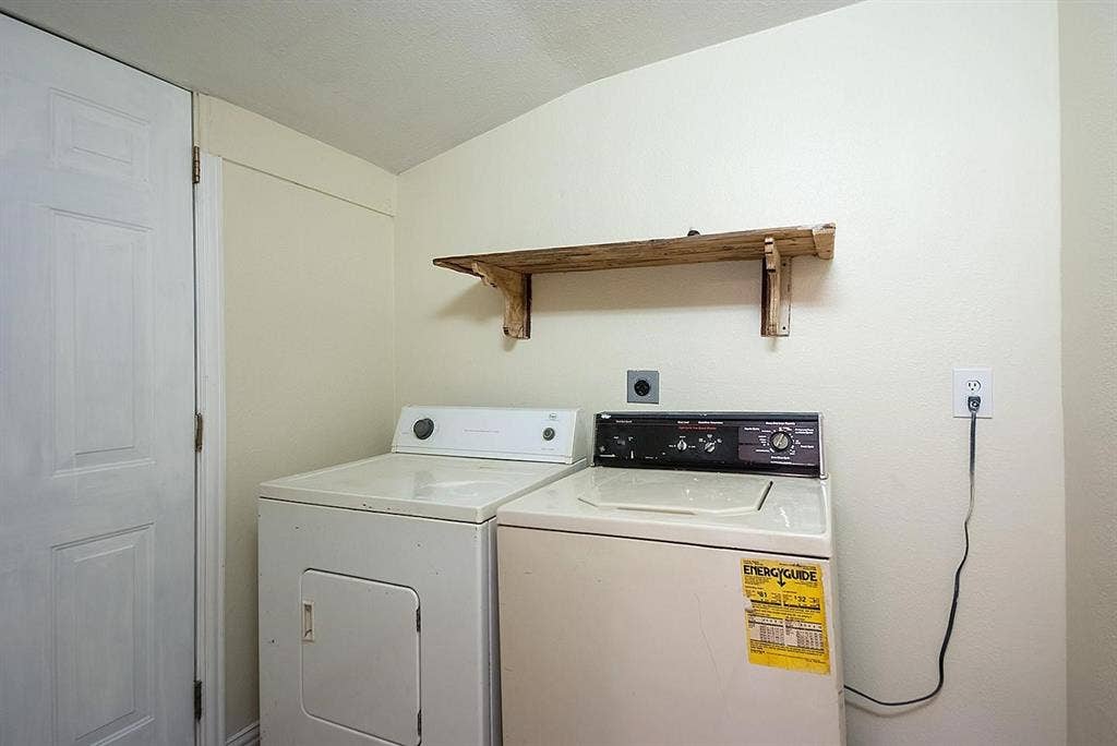 5405 Worth Street, Dallas, TX 75214 Utility room with a side-by-side washer and dryer, neatly arranged with a shelf above for storage.