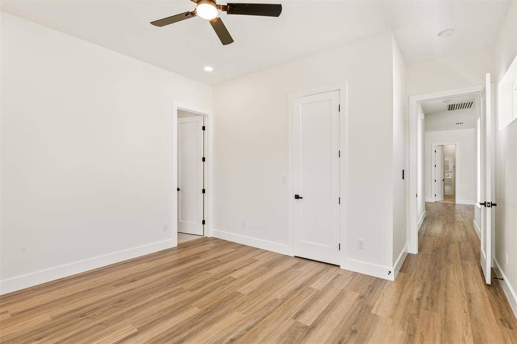 1407 Pueblo Street, Dallas, TX 75212 Bright interior space featuring wood-finish flooring, white walls, and a ceiling fan with integrated lighting