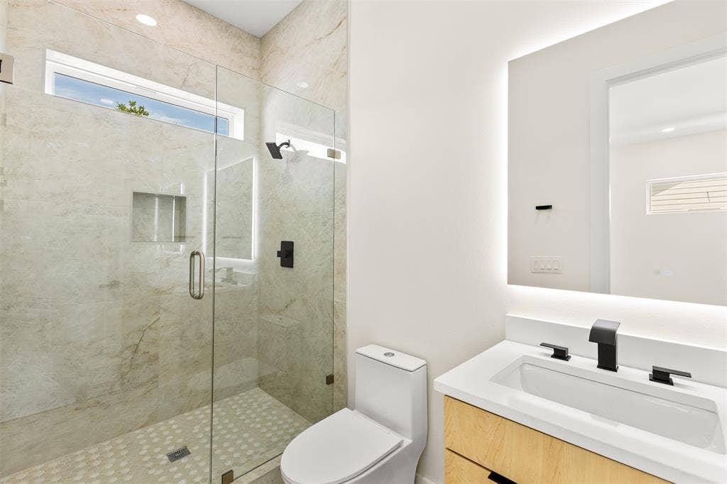 1407 Pueblo Street, Dallas, TX 75212 Bathroom featuring a glass-enclosed shower with full-height tile surround, a built-in shower niche, and a transom window