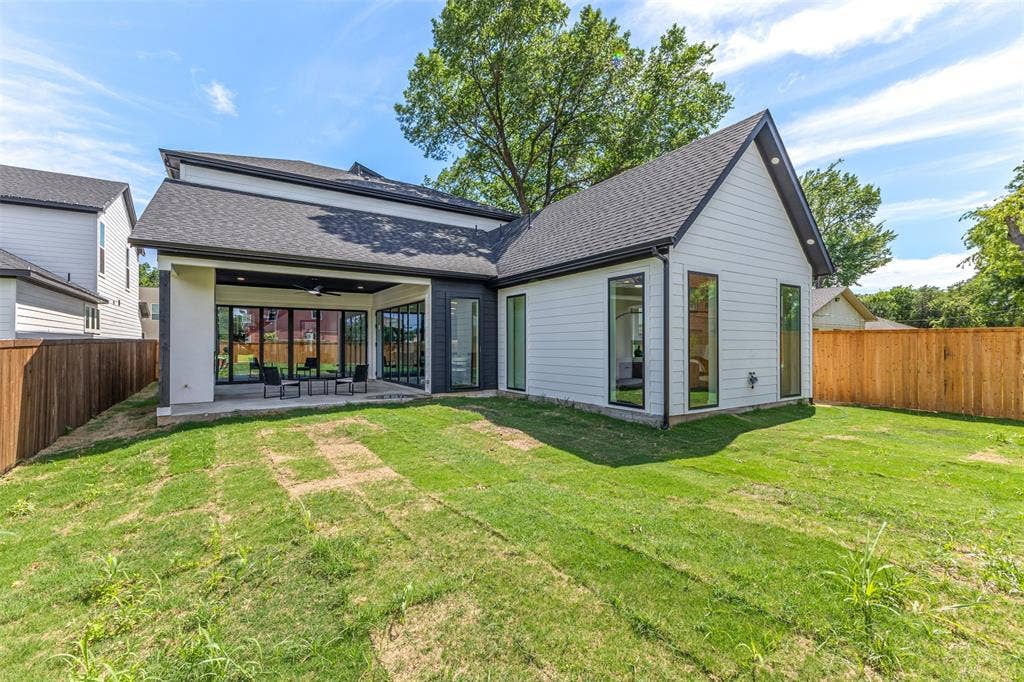 1407 Pueblo Street, Dallas, TX 75212 Modern white siding exterior with a dark-pitched roof and a covered patio