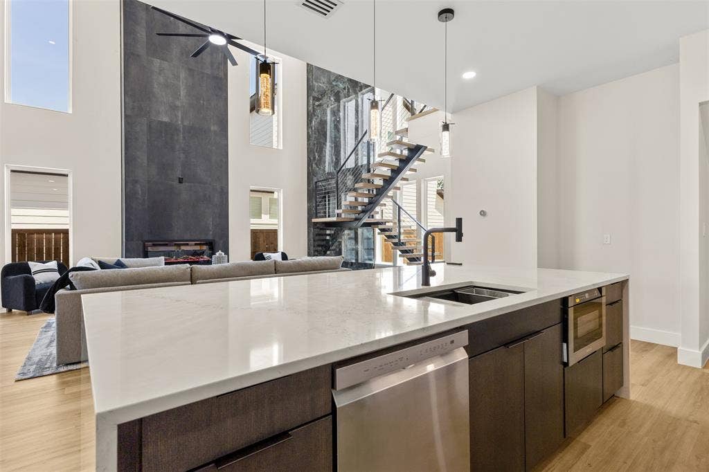 1407 Pueblo Street, Dallas, TX 75212 Expansive kitchen island featuring a light-toned countertop, stainless steel dishwasher, and built-in microwave drawer