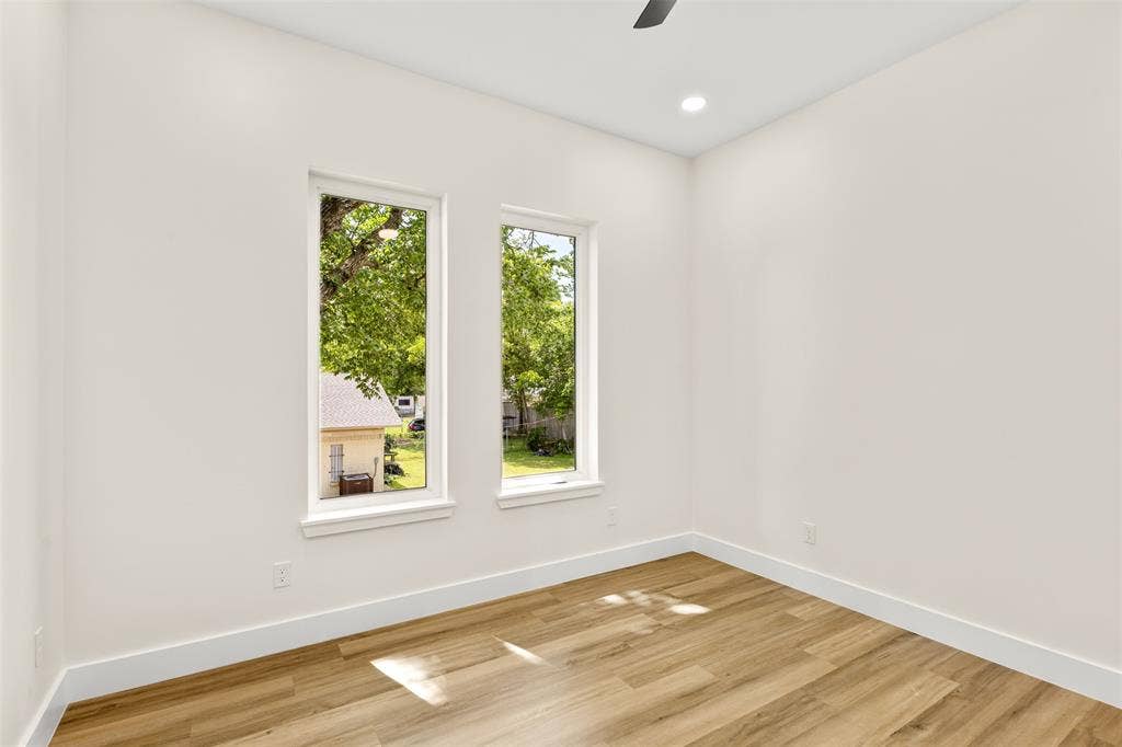 1407 Pueblo Street, Dallas, TX 75212 Neutral-toned room featuring two tall, rectangular windows, wood-finish flooring, recessed lighting, and a ceiling fan