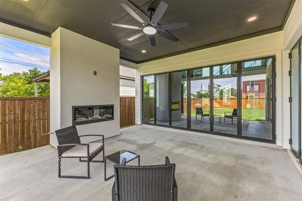 1407 Pueblo Street, Dallas, TX 75212 Covered outdoor patio with a built-in linear fireplace, concrete flooring, and a ceiling fan