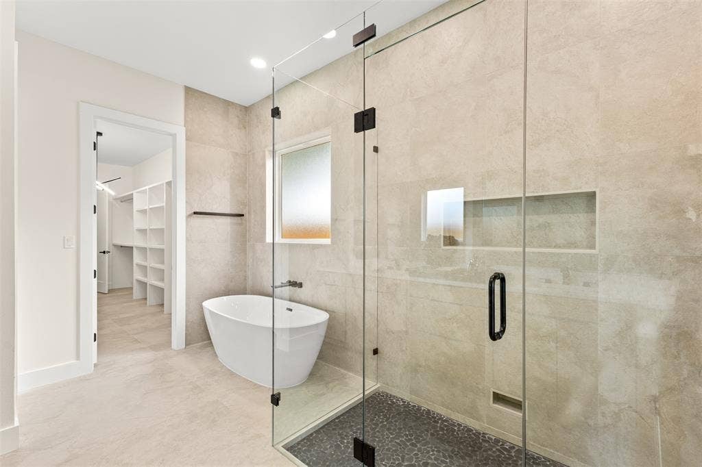 1407 Pueblo Street, Dallas, TX 75212 Contemporary bathroom featuring a frameless glass shower enclosure, a freestanding soaking tub, and a frosted window