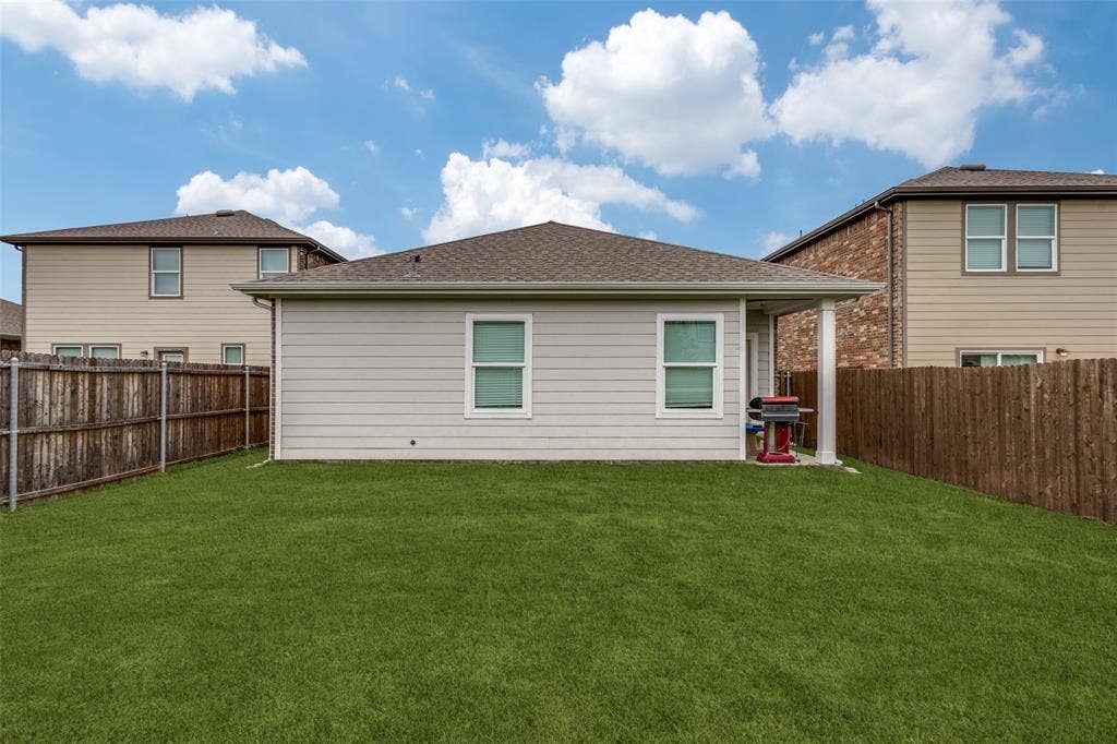 Expansive green lawn with a privacy fence