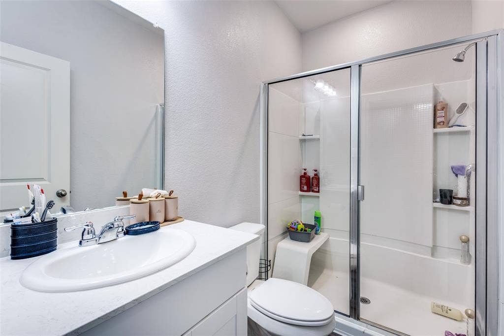 Bathroom featuring a white vanity with an undermount sink, chrome faucet, and a framed mirror