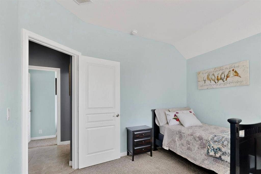 698 Langdon Street, Lavon, TX 75166 Bedroom featuring a vaulted ceiling and light blue walls