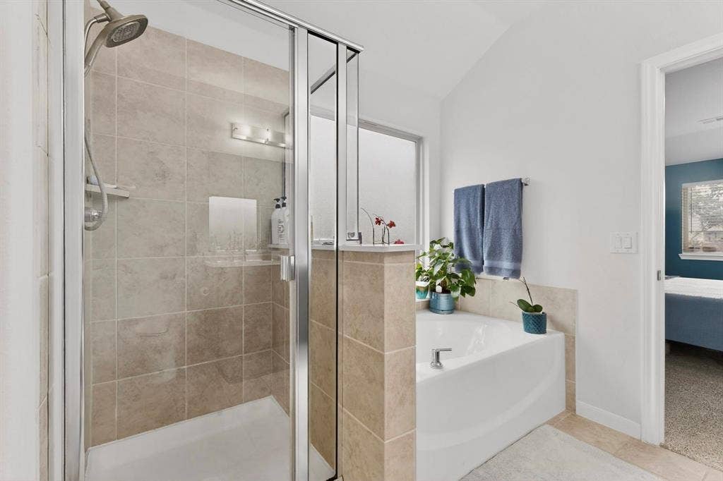 698 Langdon Street, Lavon, TX 75166 Tiled walk-in shower with clear glass enclosure and built-in niche