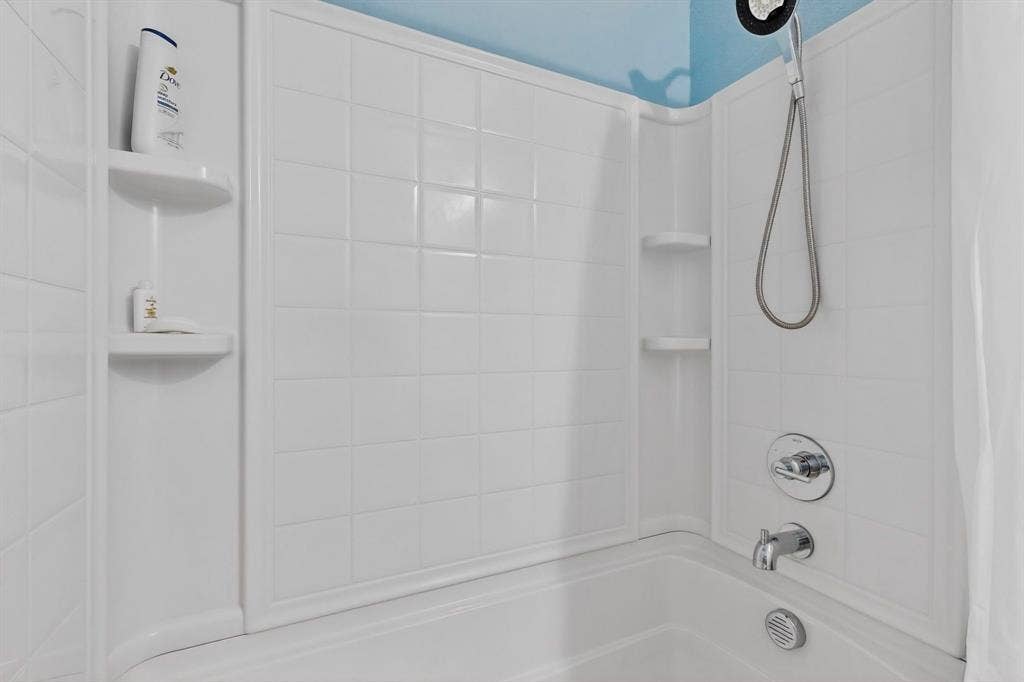 698 Langdon Street, Lavon, TX 75166 White tiled shower surround with an integrated bathtub