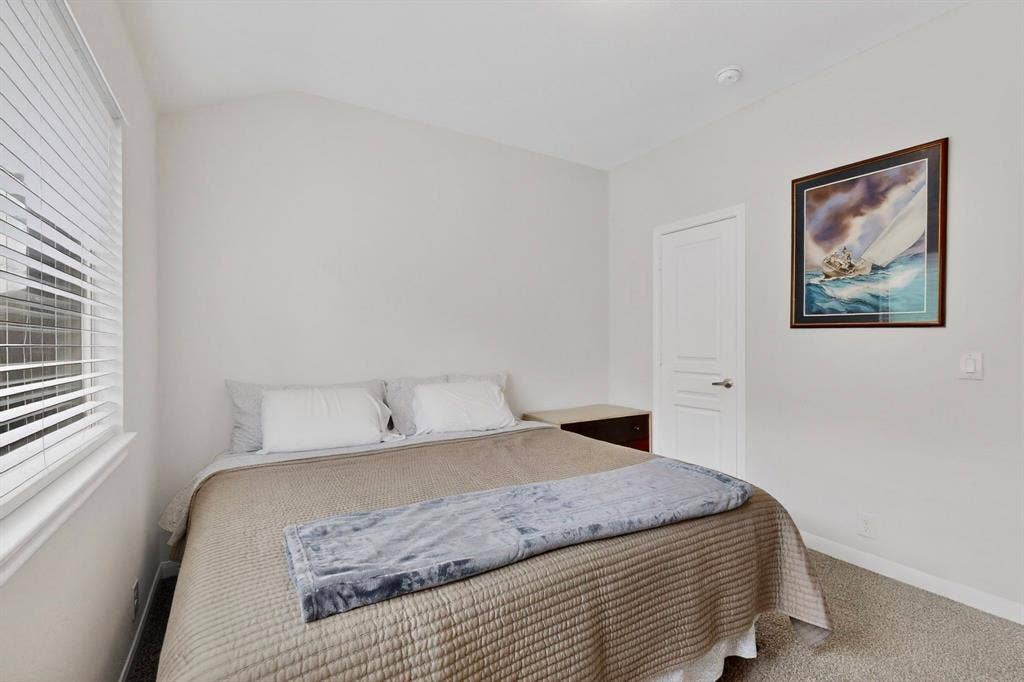 698 Langdon Street, Lavon, TX 75166 Bedroom featuring light gray wall paint, textured carpet flooring, and a window with white horizontal blinds