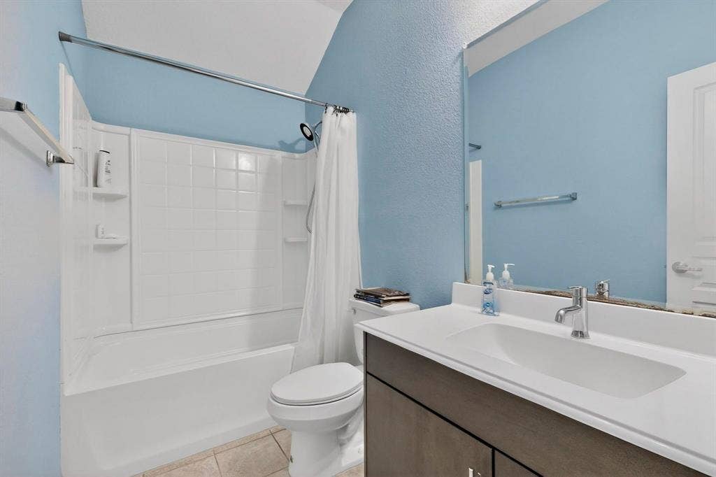 698 Langdon Street, Lavon, TX 75166 Bathroom with a single vanity featuring an integrated white sink, chrome faucet, and dark wood-finish cabinetry