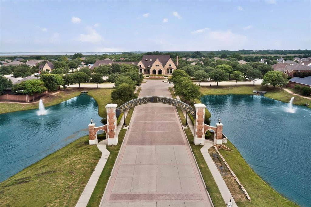 698 Langdon Street, Lavon, TX 75166 Grand entrance featuring a decorative archway, brick and stone pillars, and flanking waterways with fountains