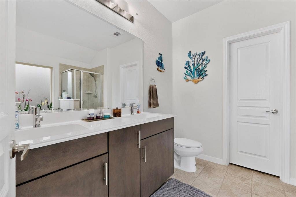 698 Langdon Street, Lavon, TX 75166 Dual vanity with integrated sinks, contemporary dark wood-finish cabinetry, brushed nickel hardware, and a large mirror