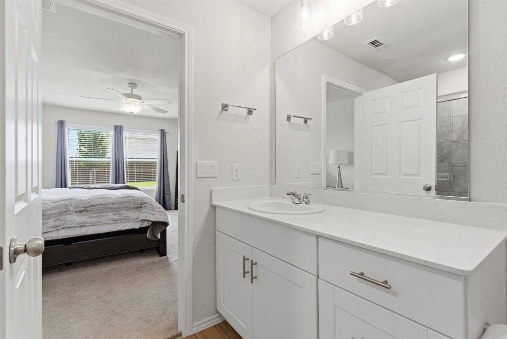 Bathroom vanity featuring a silestone quartz countertop with an undermount sink and chrome faucet