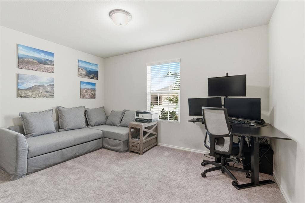 Carpeted room with white walls and a single window with blinds and a walk in closet
