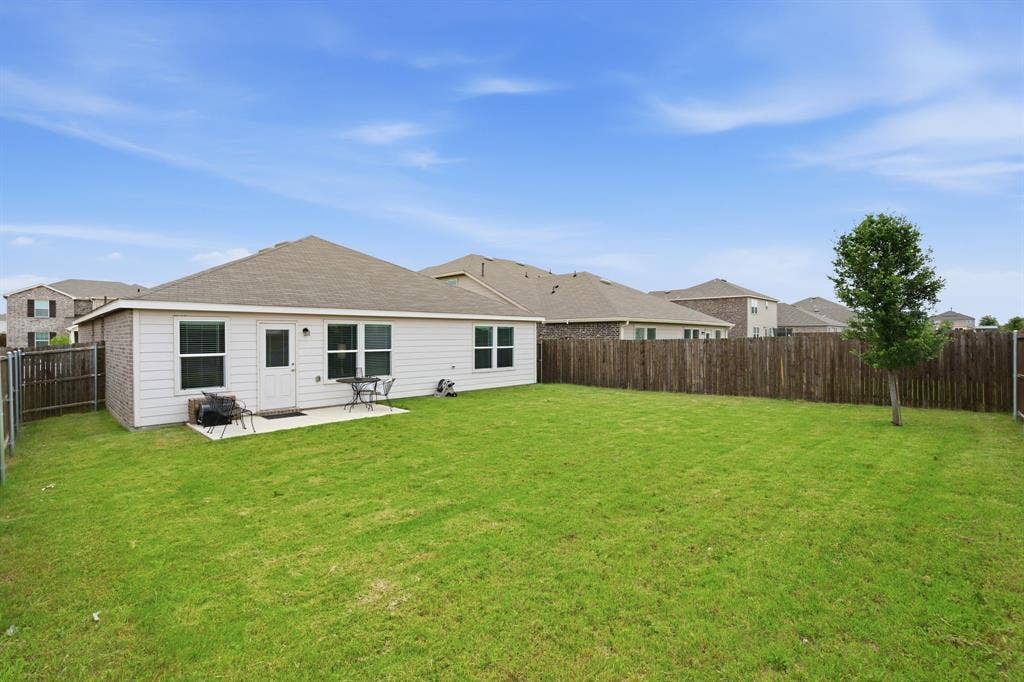 Expansive backyard featuring a manicured lawn and a privacy fence and plenty o room for entertaining and relaxing.