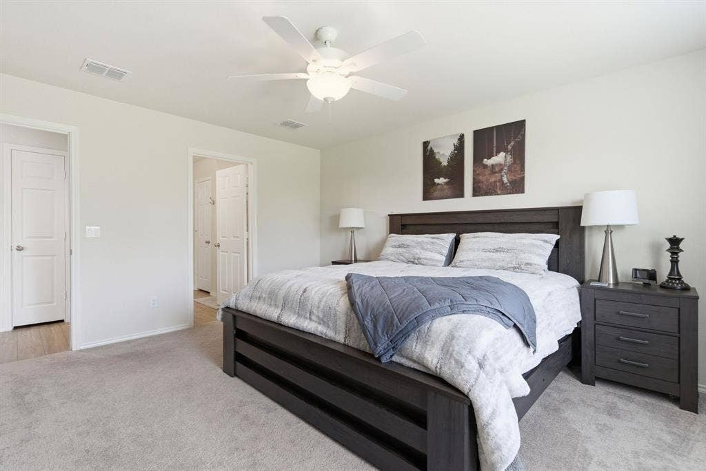Carpeted primary with ensuite and a ceiling fan