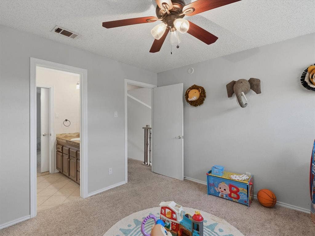 2812 Prescott Drive, Carrollton, TX 75006 Carpeted room with light gray walls, a ceiling fan with wood-finish blades, and white trim