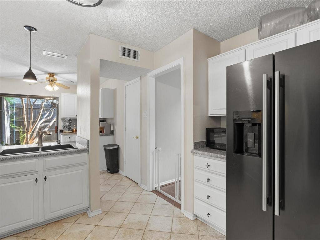 2812 Prescott Drive, Carrollton, TX 75006 Kitchen featuring white cabinetry, light-toned tiled flooring, and dark-finish appliances