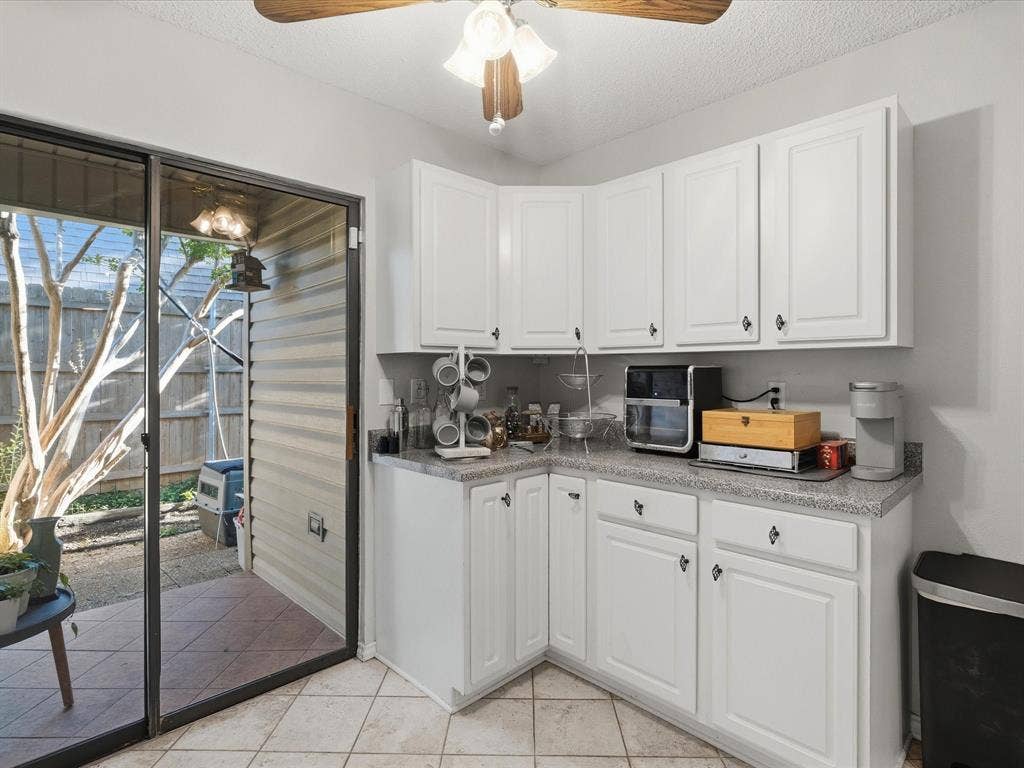 2812 Prescott Drive, Carrollton, TX 75006 White shaker-style cabinetry with dark hardware and a speckled countertop