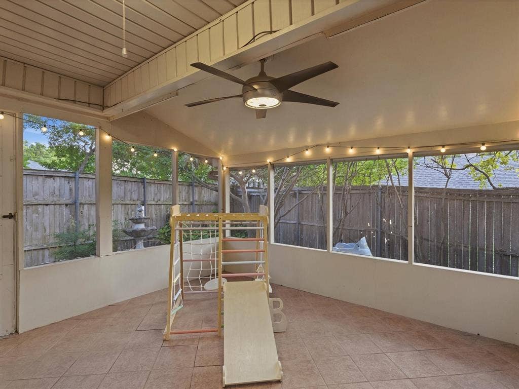 2812 Prescott Drive, Carrollton, TX 75006 Screened porch featuring a ceiling fan, string lighting, tiled flooring, and a stone fountain