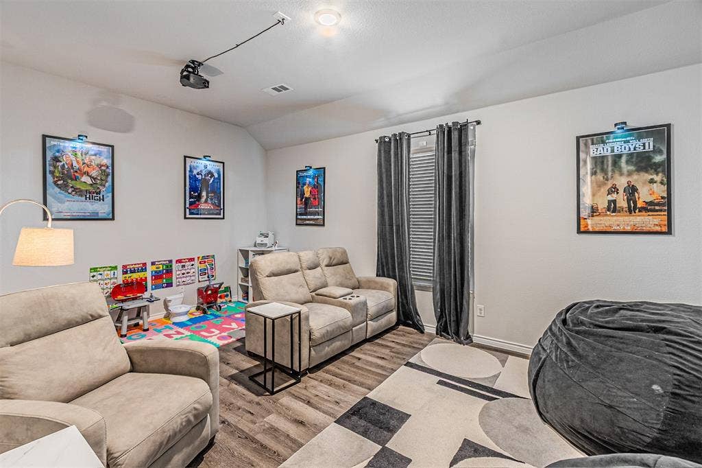 Entertainment space featuring wood-finish flooring and a ceiling-mounted projector