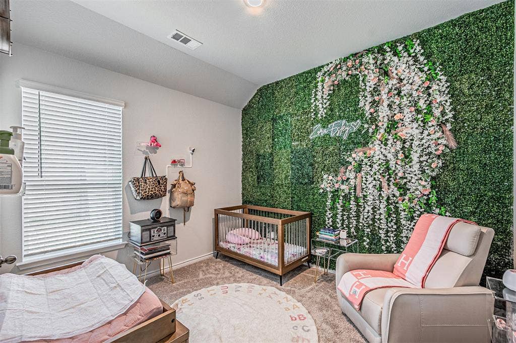 Accent wall featuring a faux foliage installation with floral embellishments