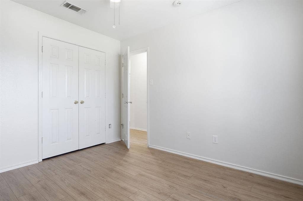 Light wood-finish flooring with white baseboards throughout