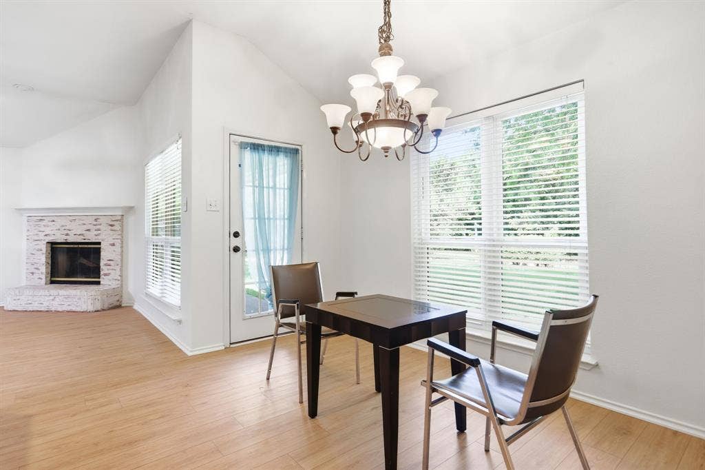Open-concept living space featuring wood-finish flooring, a kitchen island, stainless steel appliances, and a vaulted ceiling