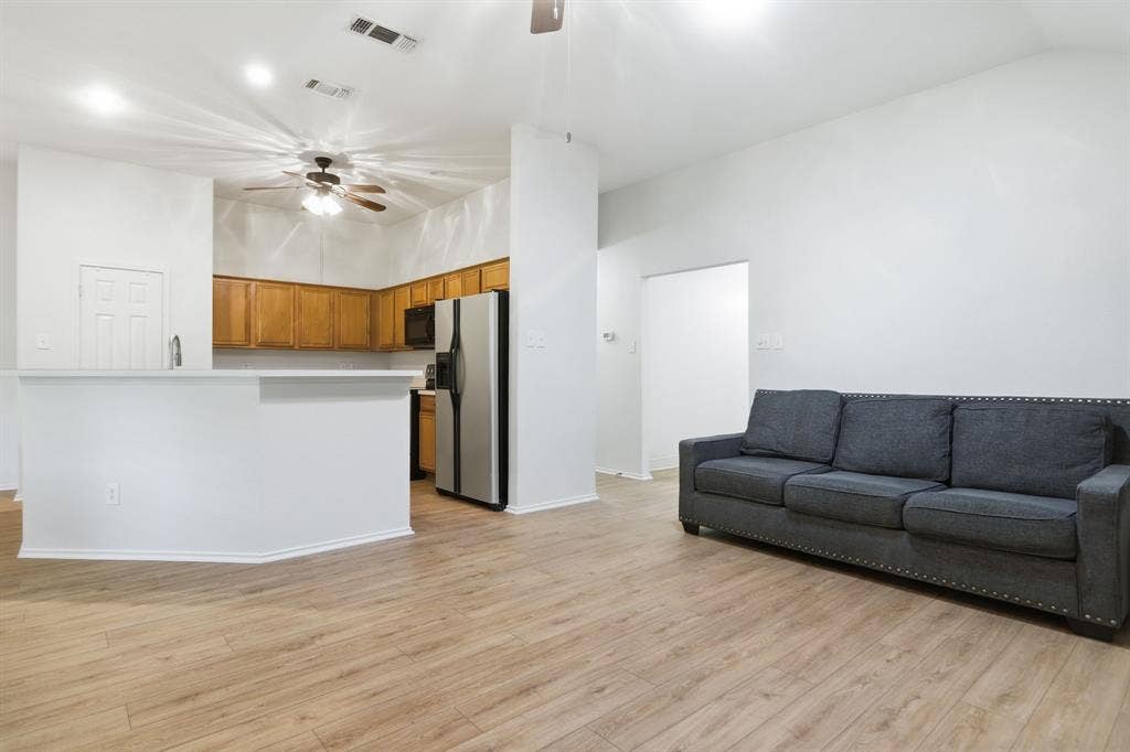Open-concept living area featuring wood-finish flooring, recessed lighting, and a neutral color palette