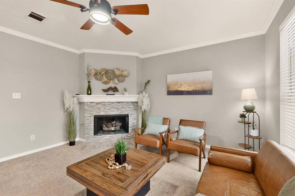 712 Water Oak Drive, Plano, TX 75025 Living area featuring a corner fireplace with a stacked stone facade and white mantel