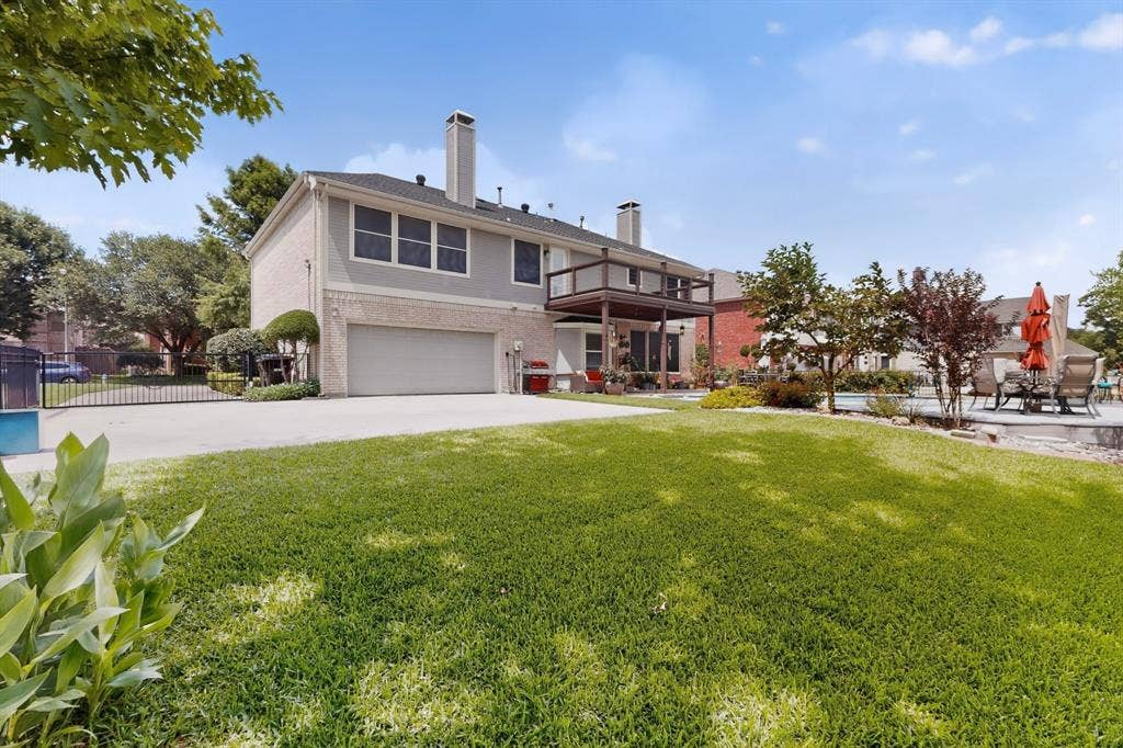 712 Water Oak Drive, Plano, TX 75025 Spacious backyard featuring a large green lawn, mature landscaping, and an expansive pool deck