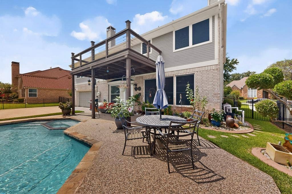 712 Water Oak Drive, Plano, TX 75025 Expansive backyard featuring a built-in pool with spa, an upper deck with cable railing, a covered patio, and a gravel-finish patio