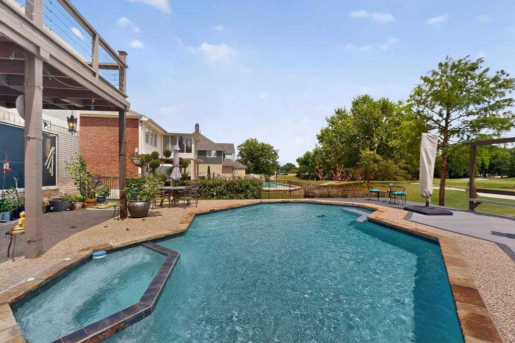 712 Water Oak Drive, Plano, TX 75025 Backyard oasis featuring a freeform pool, integrated spa, and expansive aggregate decking