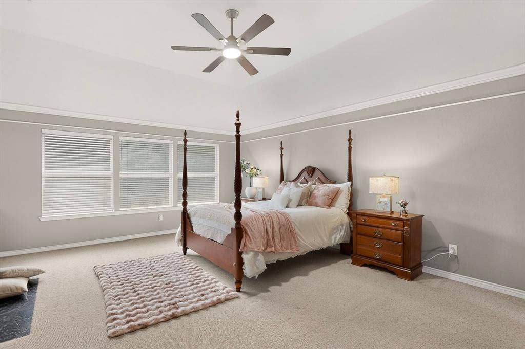 712 Water Oak Drive, Plano, TX 75025 Carpeted room featuring a vaulted ceiling with a ceiling fan, crown molding, and a row of three windows with blinds