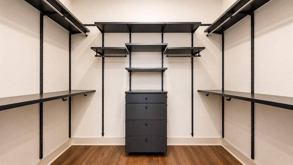3330 Oak Grove Avenue, #1307, Dallas, TX 75204 Custom closet system featuring dark wood-finish flooring, white walls, and a central five-drawer dresser