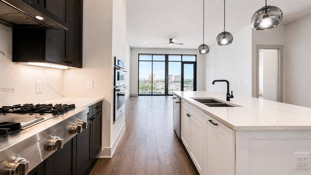 3330 Oak Grove Avenue, #1307, Dallas, TX 75204 Contemporary kitchen featuring a gas cooktop, double wall ovens, and an expansive island with a double sink
