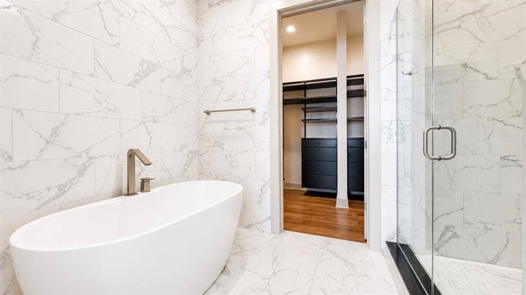 3330 Oak Grove Avenue, #1307, Dallas, TX 75204 Freestanding soaking tub with brushed nickel fixtures set against marble-look tile walls