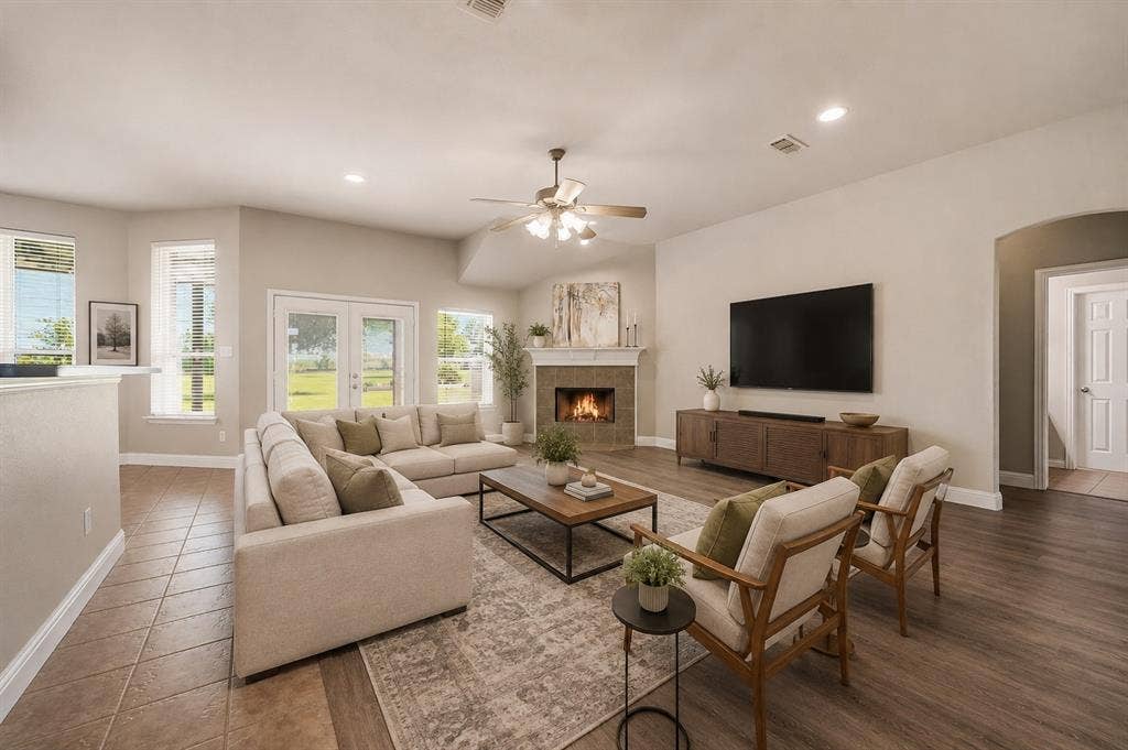**Virtually staged**Spacious living room featuring a gas fireplace with a wood mantel, recessed ceiling lighting, and a ceiling fan