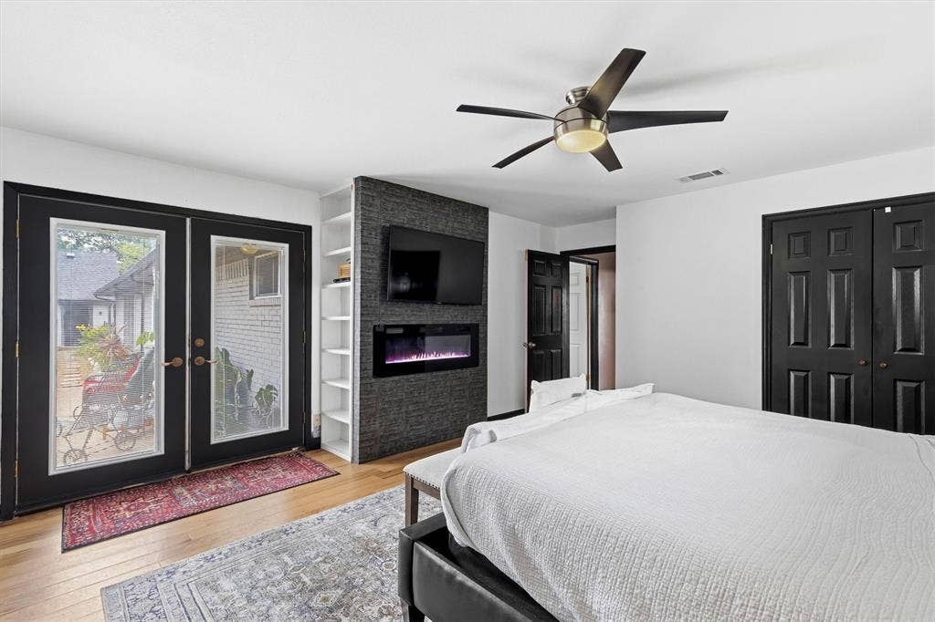 216 Meadowlark Lane, Wylie, TX 75098 Primary Bedroom with French doors to Back yard and Decorative Fireplace.