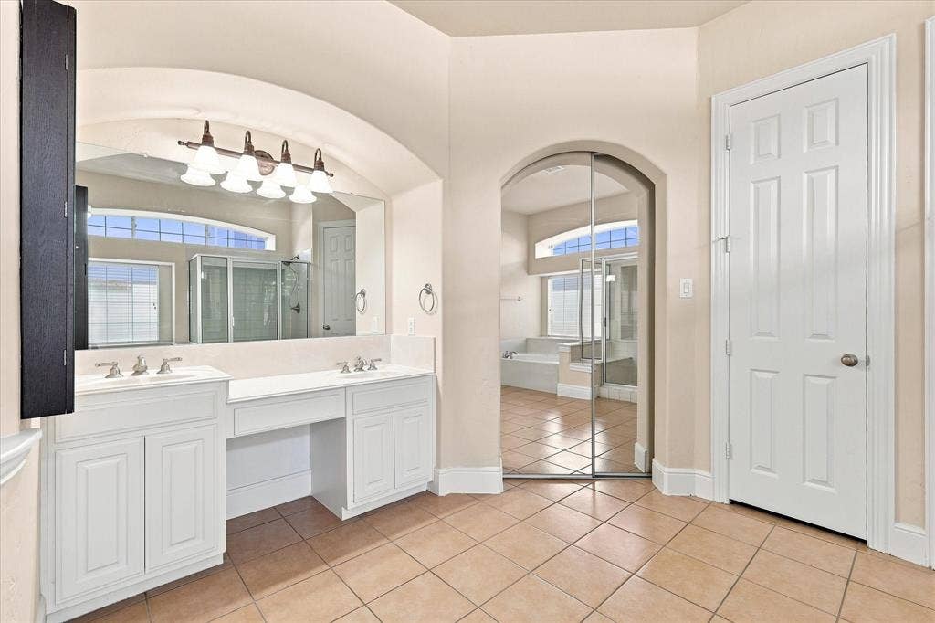 509 Wentworth Lane, Murphy, TX 75094 Dual vanity with white cabinetry, a built-in makeup area, and a large wall-mounted mirror